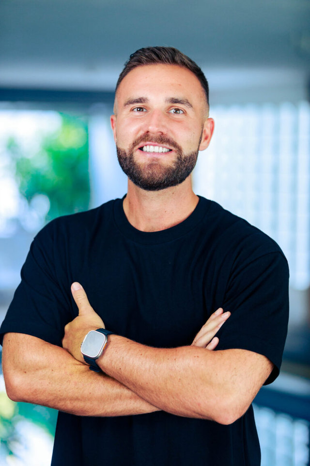 Karl Hudson, photographed in a black T-shirt with his arms folded